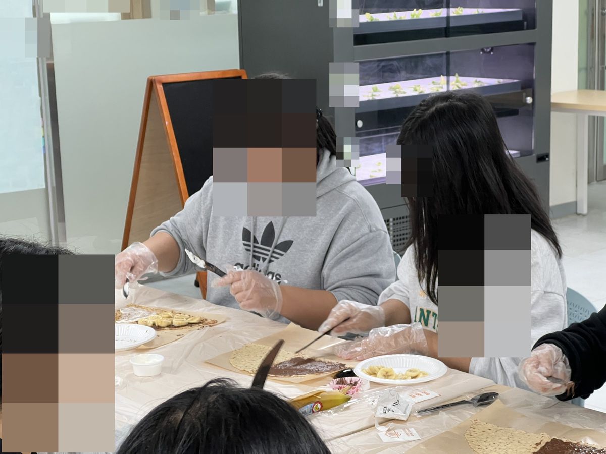 한 책상에 놓인 초코를 바른 크레페와 바나나를 올린 크레페