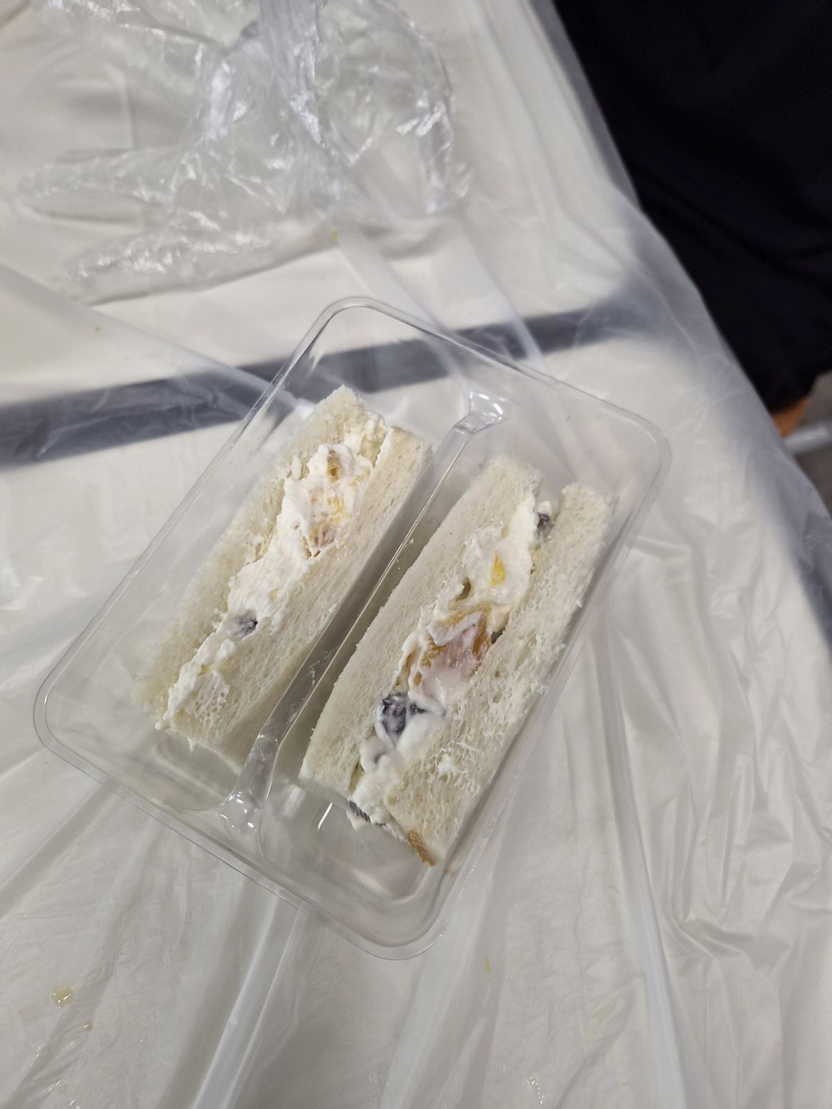 투명 용기 안에 나란히 담긴 샌드위치 두 조각