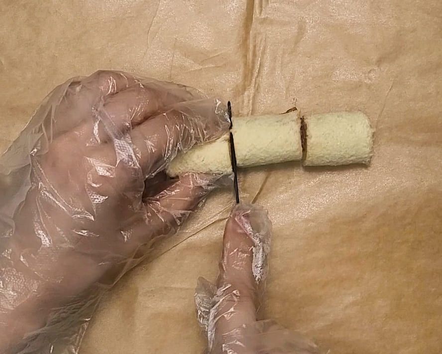말아 둔 롤을 플라스틱 칼로 세 조각으로 자르는 손